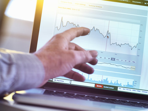 Investor viewing company share price market data on a laptop computer