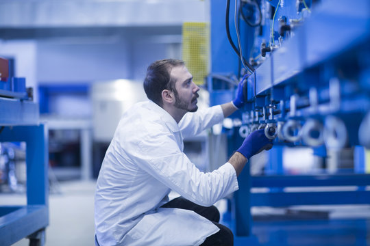 Scientist inspecting heavy machinery