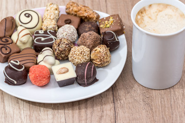 many delicious sweets with cup of cappuccino on the table.