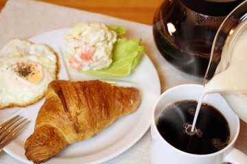 コーヒーにミルクを注ぐ
