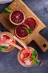 Bloody orange cocktail garnished with mint in the jars. View from above, top studio shot