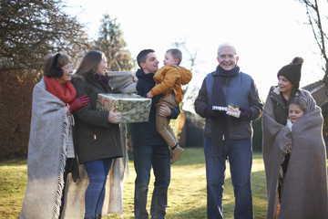 Family standing together at birthday celebration in garden