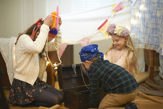 Boy and two sisters dressing up from treasure chest