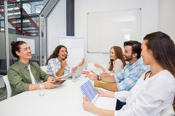 Smiling executive interacting during meeting in conference room