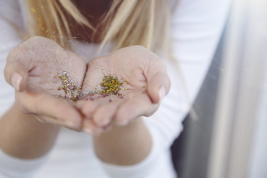 Cupped hands of woman holding glitter