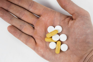 Medicine pills and capsules in hand on white background, Antibiotic, painkiller close up.
