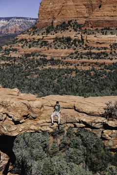 Man sitting on Devil's Bridge, Sedona, Arizona, USA