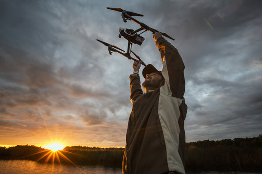 Man launching drone at sunrise, Homosassa, Florida, USA