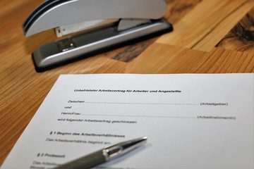 Unbefristeter Arbeitsvertrag für Arbeiter und Angestellte auf einem Schreibtisch