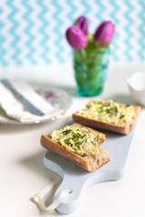 Fototapeta na wymiar Crispy baguette sandwich with egg spread on chopping board