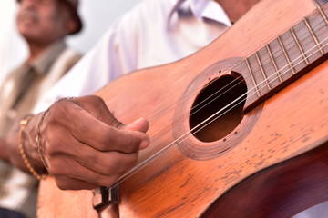 Street musician playing traditional cuban music on an acoustic guitar for the entertainment of tourists in Trinidad, Cuba