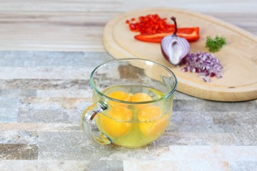 Making egg omelette with cut onion, red pepper  & garden cress