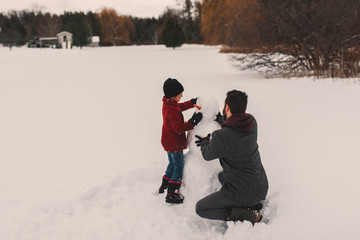 Father and daughter making snowman
