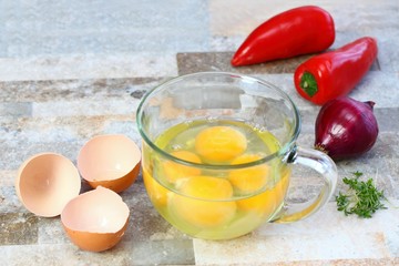 Making egg omelette with cut onion, red pepper  & garden cress