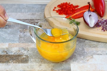 Making egg omelette with cut onion, red pepper  &  garden cress