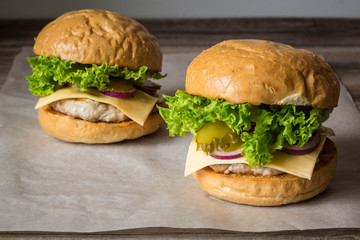 home made tasty burgers on wooden table.