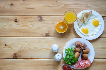 Orange juice, Two eggs and sausage for healthy breakfast.