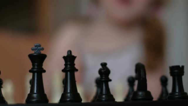 Little beautiful girl playing chess