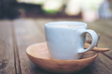 A blue cup of hot Latte coffee on vintage wooden table and blur background 