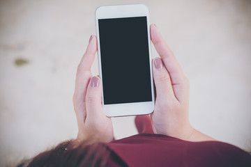 Mockup image of a woman holding white mobile phone with blank black screen   