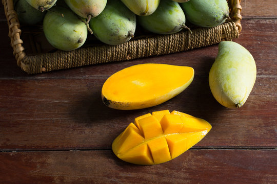 Mangoes ripe on basket and olden wooden table