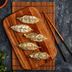 Fresh dumplings on a dark stone background.