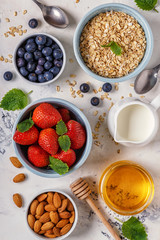 Healthy breakfast - a bowl of oatmeal, berries and fruit, top view.