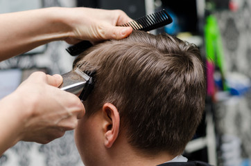 Barber cutting and modeling hair by electric trimmer