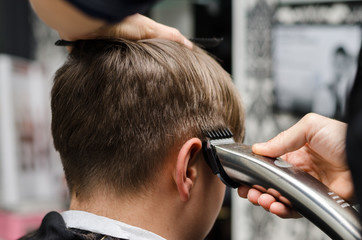 Barber cutting and modeling hair by electric trimmer