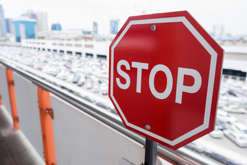 Stop sign against car parking background.