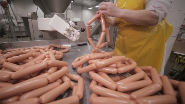 Sausages industrial production. Worker at a manufacturing plant. HD.