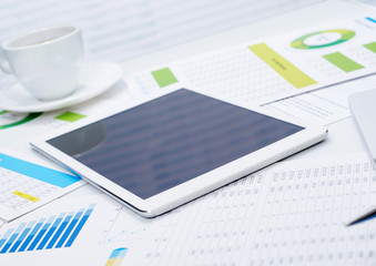 Tablet on financial papers