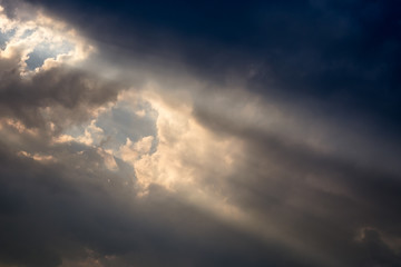 A ray of sunlight breaking through dark clouds.