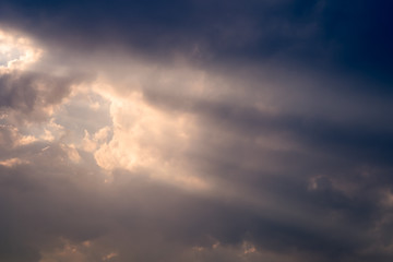 A ray of sunlight breaking through dark clouds.