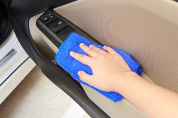 Woman hands cleaning car using microfiber cloth.