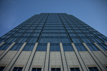 Tall concrete, glass and steel building surrounded by clear blue sky