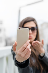 Portrait of a young attractive woman making selfie photo on smartphone