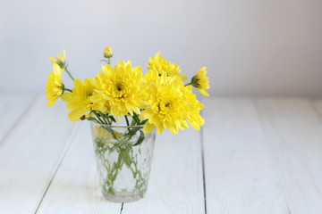 bouquet of yellow Chrysanthemum on white wooden table, blurred light background. floral gift. festive composition with flowers. template for design
