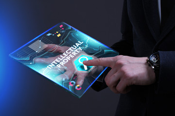 Business, Technology, Internet and network concept. Young businessman working on a virtual screen of the future and sees the inscription: Intellectual property