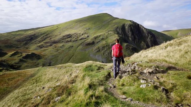 A hiker walking along Scar Crags towards Crag Hill in the English Lake District, Cumbria, UK.
