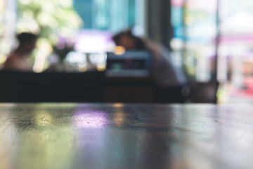 Wooden table in cafe with blur bokeh abstract vintage background