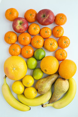 Variety of fruits, apples, tangerines, bananas, pears, lemons, limes, oranges, grapefruit on white background, view from above, isolated