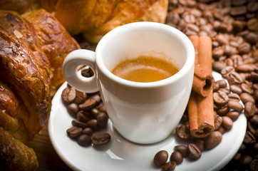 coffee cup with beans on wooden table