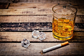 Glass of whiskey and  cigarettes. An old and vintage countertop with highlight and a glass of hard liquor