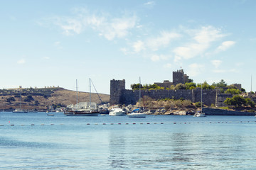 Fototapeta premium Luxury yachts (sailing boats) parked on turquoise water in front of Bodrum castle. The image shows Aegean and Mediterranean culture of coastel lifestyle.