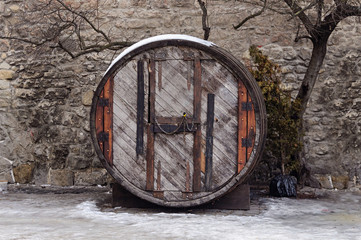 Old big oak barrel at the stone wall