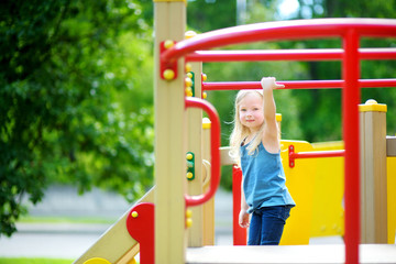 Cute little girl having fun on a playground outdoors