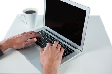 Fototapeta na wymiar Businessman using laptop while having coffee