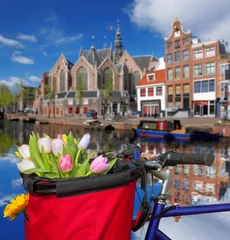Keuken spatwand met foto Famous Amsterdam with basket of colorful tulips against canal in Holland © Tomas Marek