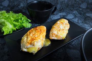 Chicken breast spicy with cheese, bread, vegetable (green oak) tomato sauce and coffee in dark background.